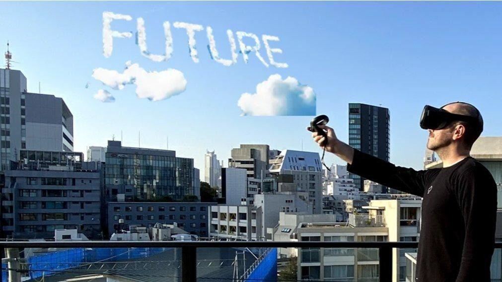 VRのゴーグルを装着した人が、空に「FUTURE」の文字を雲で描いているイメージ写真